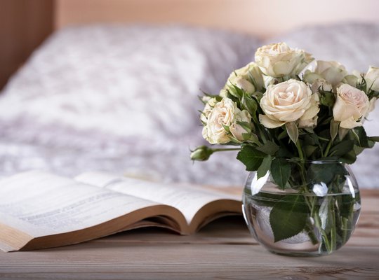 bedside table in light cozy bedroom interior.